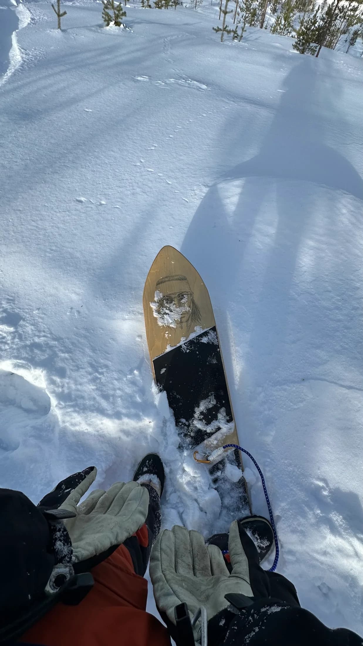 A rider's view of a snow surfboard and winter boots in soft snow